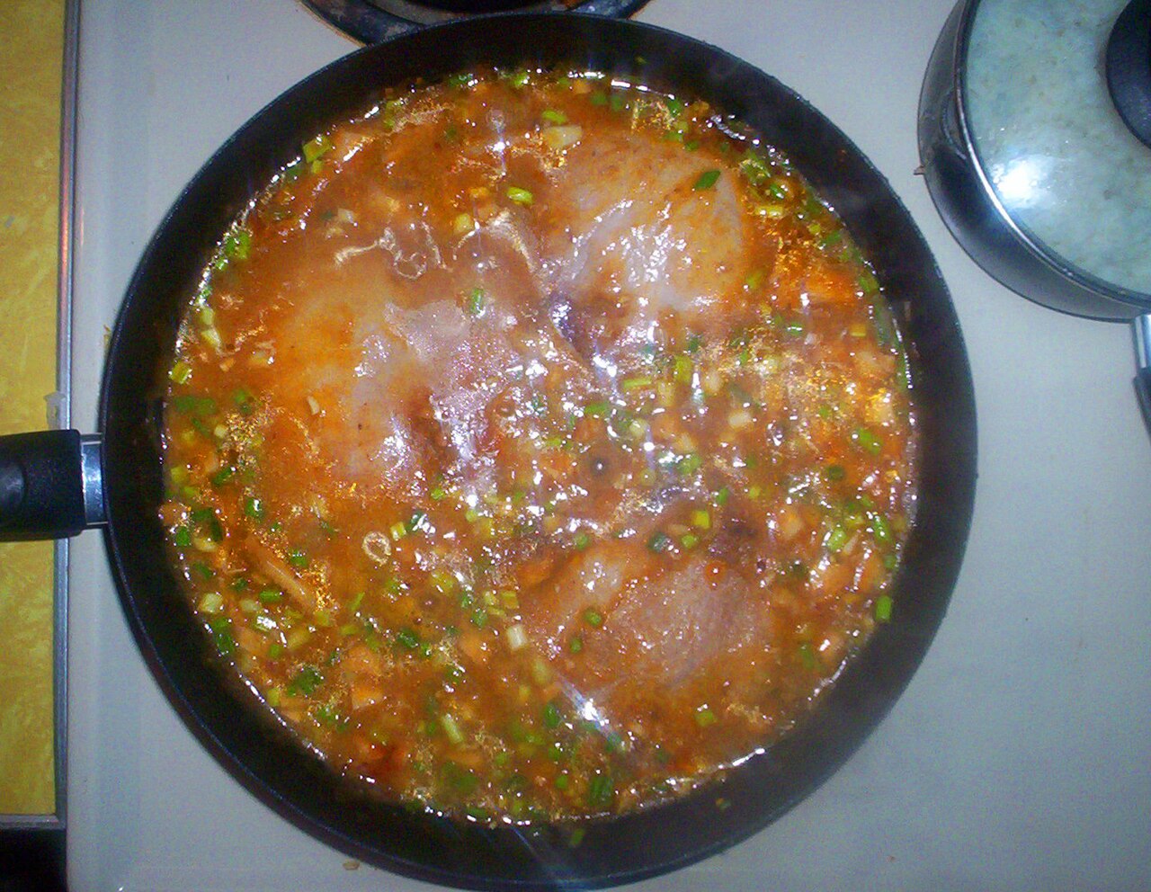 Pork chops simmering in chanterelle mushroom sauce with green onions and herbs