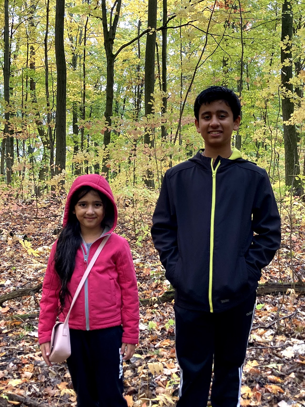 Two children standing in an Ontario forest in autumn